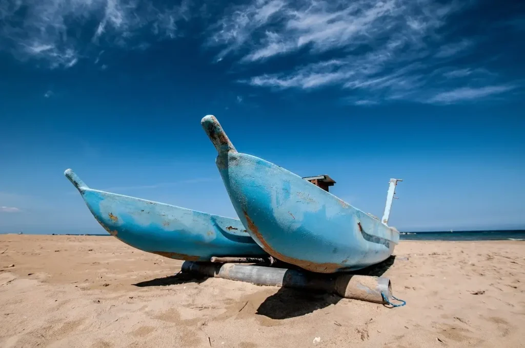 a blue boat on a beach in olbia sardinia