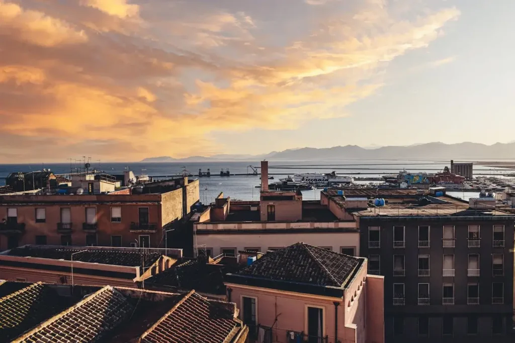 a city with a body of water and mountains in the background