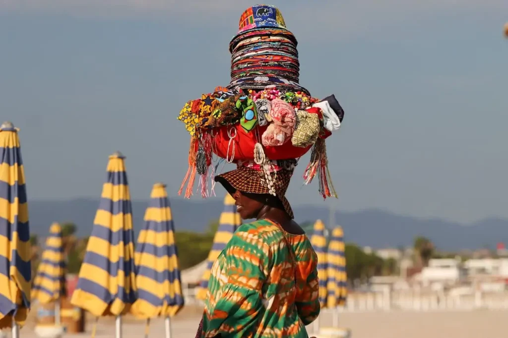 a woman carrying a pile of objects on her head